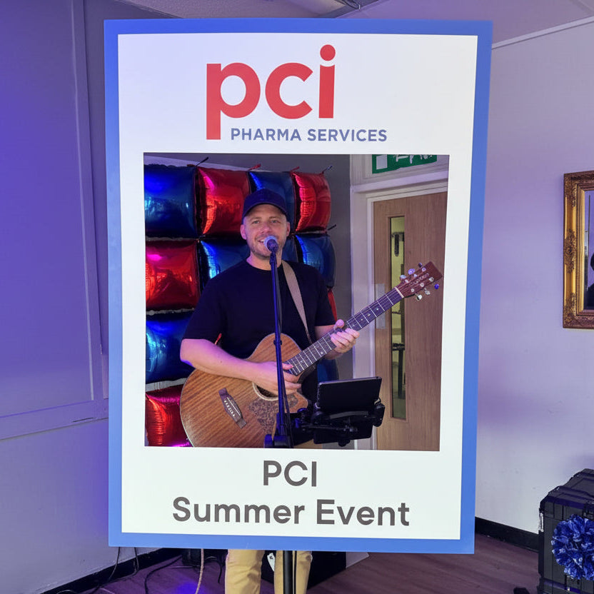 Singer holding a guitar with 'PCI Pharma Services' branding at a corporate summer event.